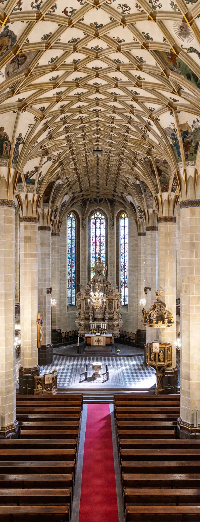 Innenansicht der St. Marien Kirche in Pirna mit gotischem Gewölbe und Blick auf den Altar.